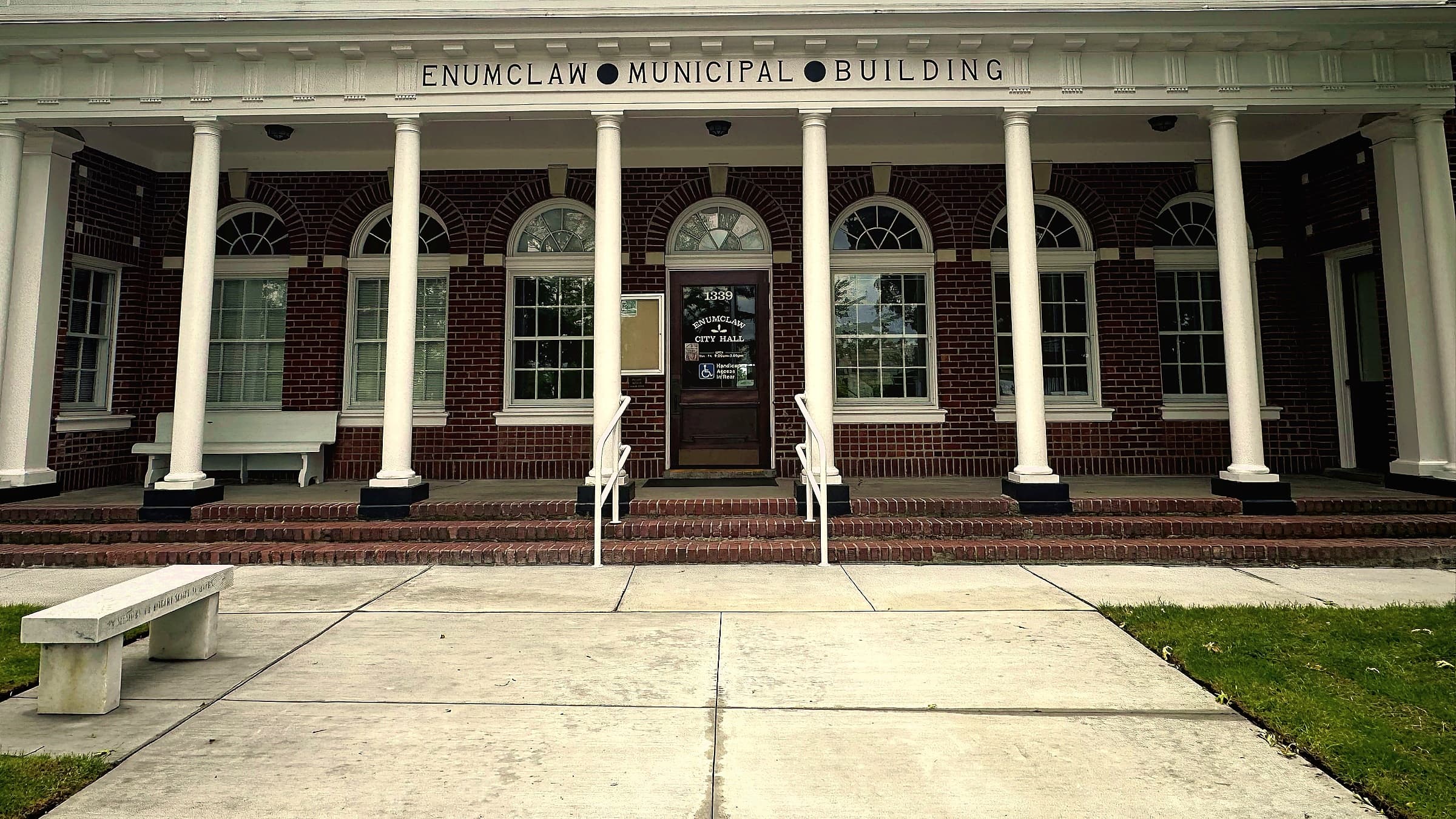 The Enumclaw Municipal Building on Griffin Avenue, a red brick building with eight white columns